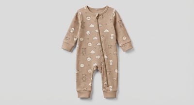 Beige baby onesie with small white motifs centered on a clean light studio background for ecommerce product photography.